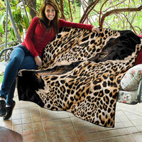 African leopard-skin pattern quilt laid out, showing black quilted texture and leopard spots