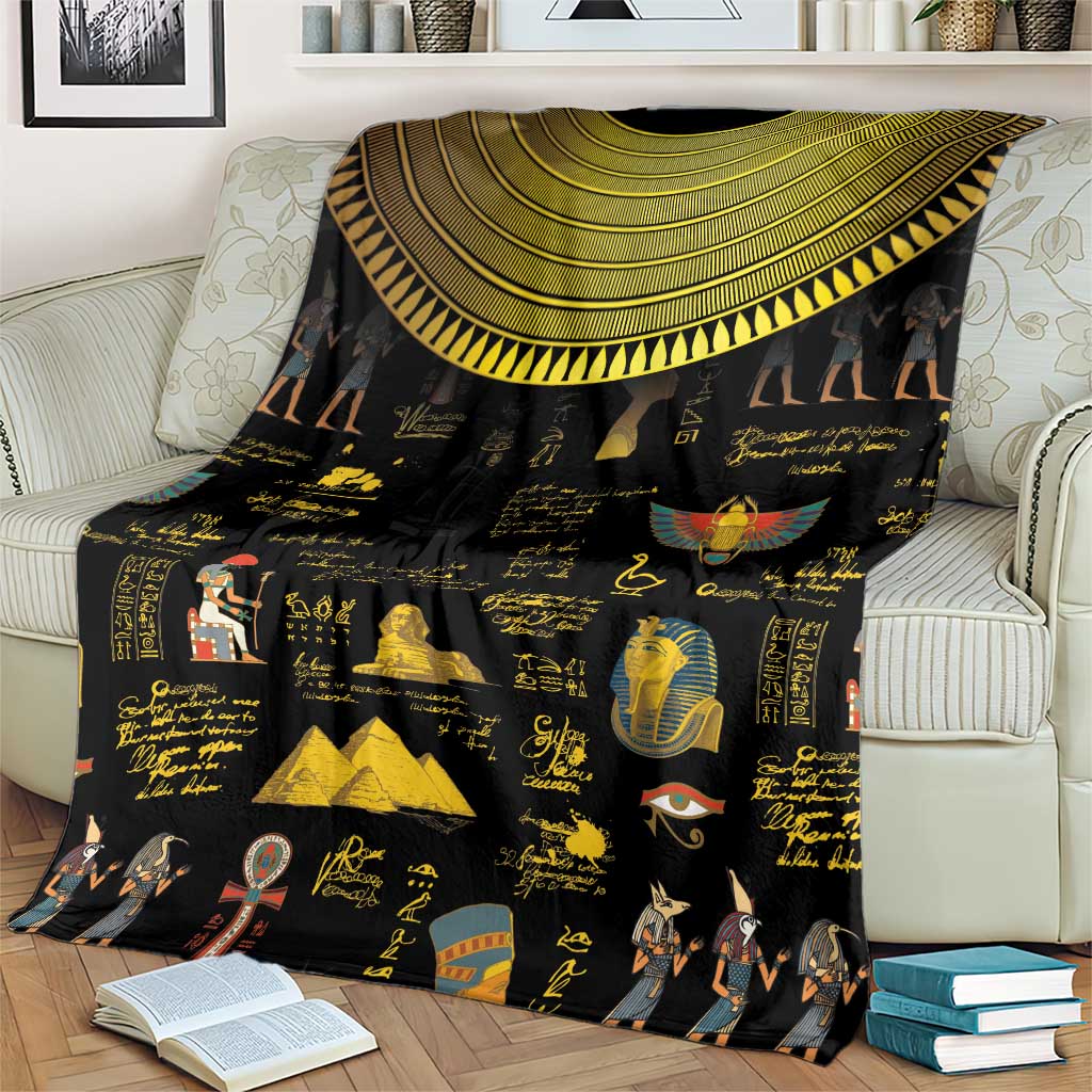 Black Egyptian blanket over armchair with gold semicircle trim and hieroglyph artwork