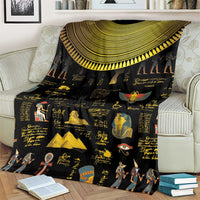 Black Egyptian blanket over armchair with gold semicircle trim and hieroglyph artwork