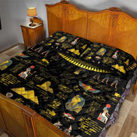 Black quilt bed set with gold Egyptian art, hieroglyphs, and two pillow shams on bed
