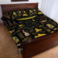 Black quilt bed set with gold hieroglyphs and Egyptian character prints; spread on bed
