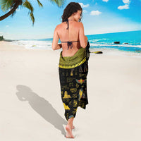 Black sarong with yellow geometric border and hieroglyph-style graphics, tied at waist