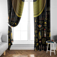 Black Egyptian window curtain with gold top valance and hieroglyph prints beside white door.