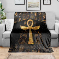 Black throw blanket with gold Ankh and Eye of Horus design, spread over sofa