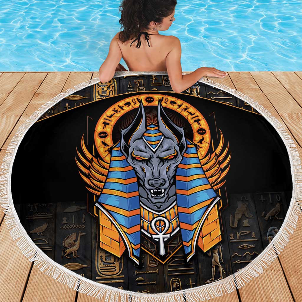 Black round Anubis beach blanket with fringe edge spread on wooden planks by a pool