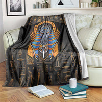 Black throw blanket with central Anubis head, blue-and-gold stripes, and Egyptian symbols