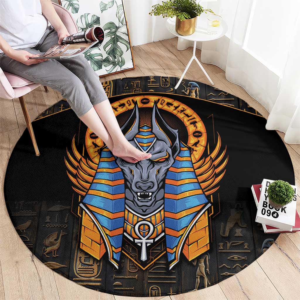 Black round carpet with central Anubis portrait in blue and gold, winged headdress