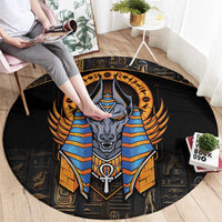Black round carpet with central Anubis portrait in blue and gold, winged headdress