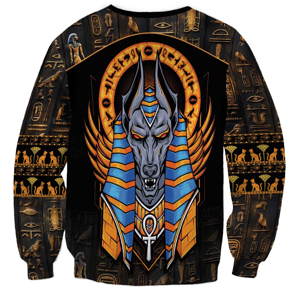 Black unisex sweatshirt with centered Anubis head graphic, blue-and-gold striped chest armor