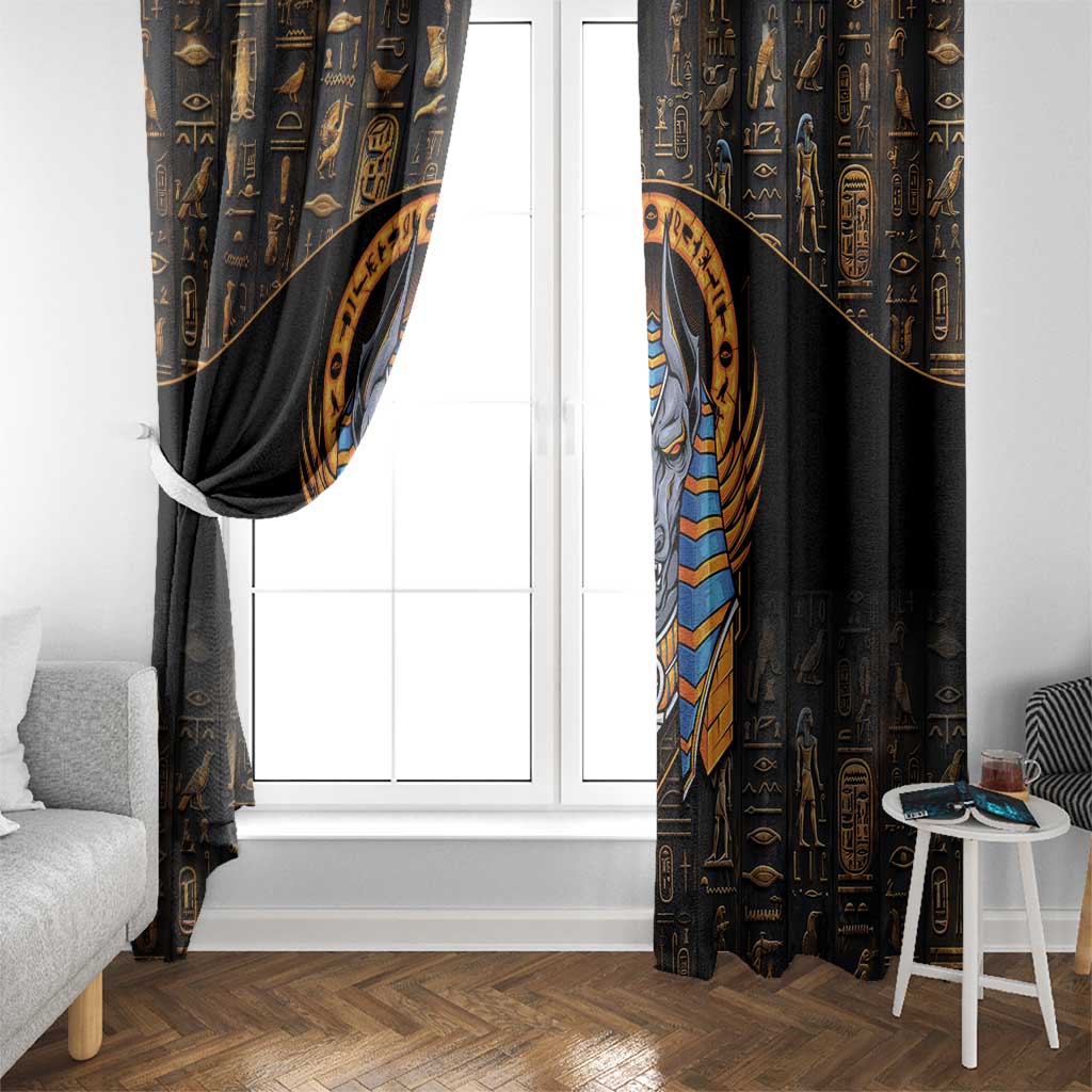 Black curtain panel with gold hieroglyphs and Anubis graphic framing a window