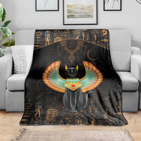 Black winged cat blanket draped on a gray sofa, with orange-blue circular wing halo