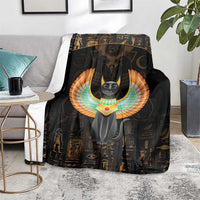 Black winged cat blanket on a gray chair seat, surrounded by gold hieroglyph icons