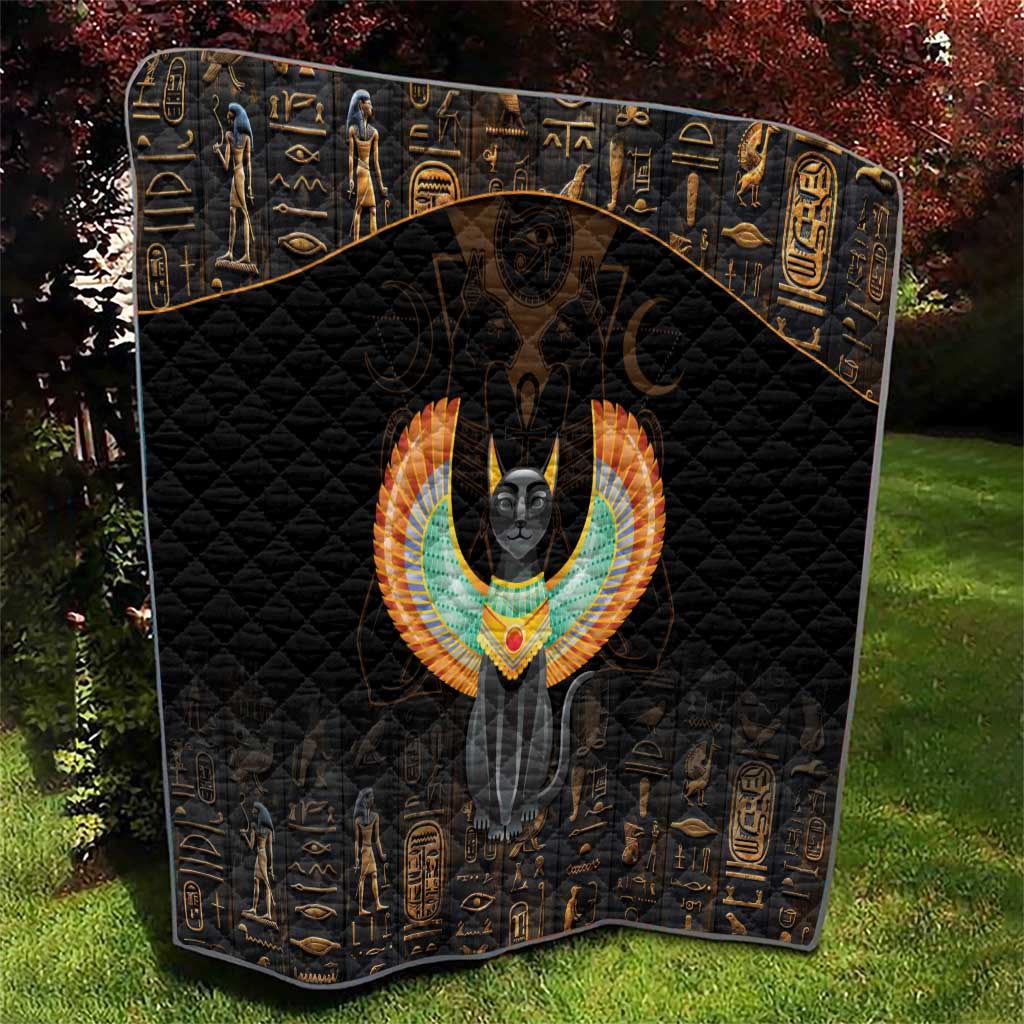 Black quilt blanket with diamond stitching and Egyptian cat wings motif on the front