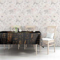 Black tablecloth with gold Egyptian motifs and winged cat centerpiece on table