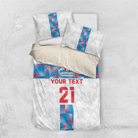 White bedding set viewed top-down: duvet cover with Luxembourg crest and blue vertical stripe