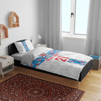 White bedding set on bed with matching pillows; blue Luxembourg stripe and “YOUR TEXT 21”