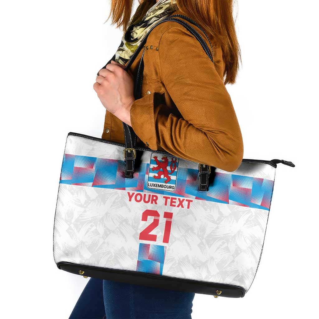 White shoulder tote bag with black handles, center crest, and red “21” text