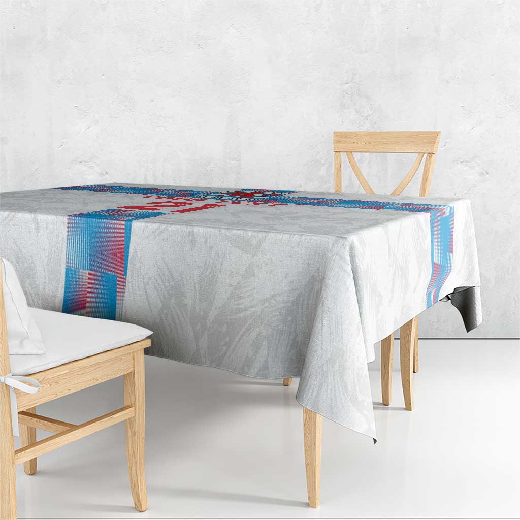 White tablecloth draped on a wooden table with blue-and-red edge trim