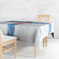 White tablecloth draped on a wooden table with blue-and-red edge trim