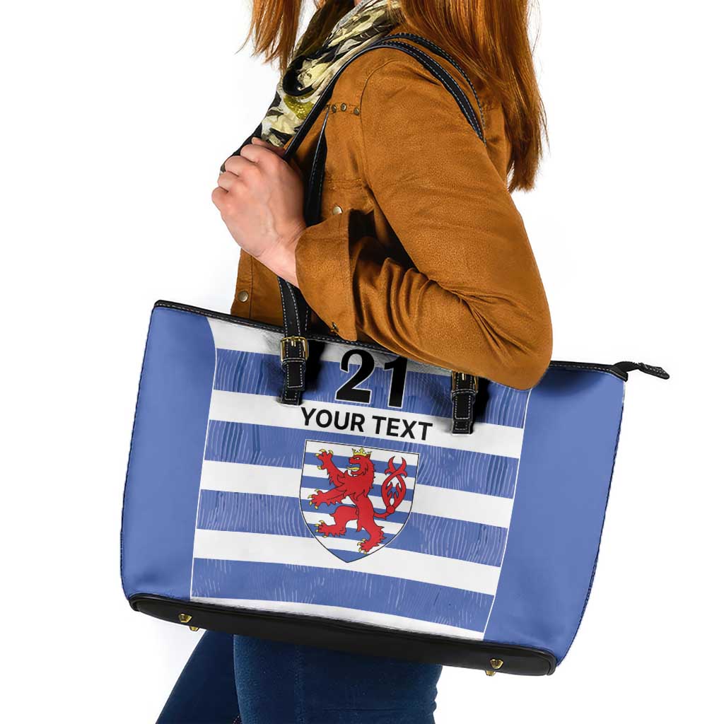 Blue leather tote bag with blue/white stripes, crest, and '21 YOUR TEXT' front.
