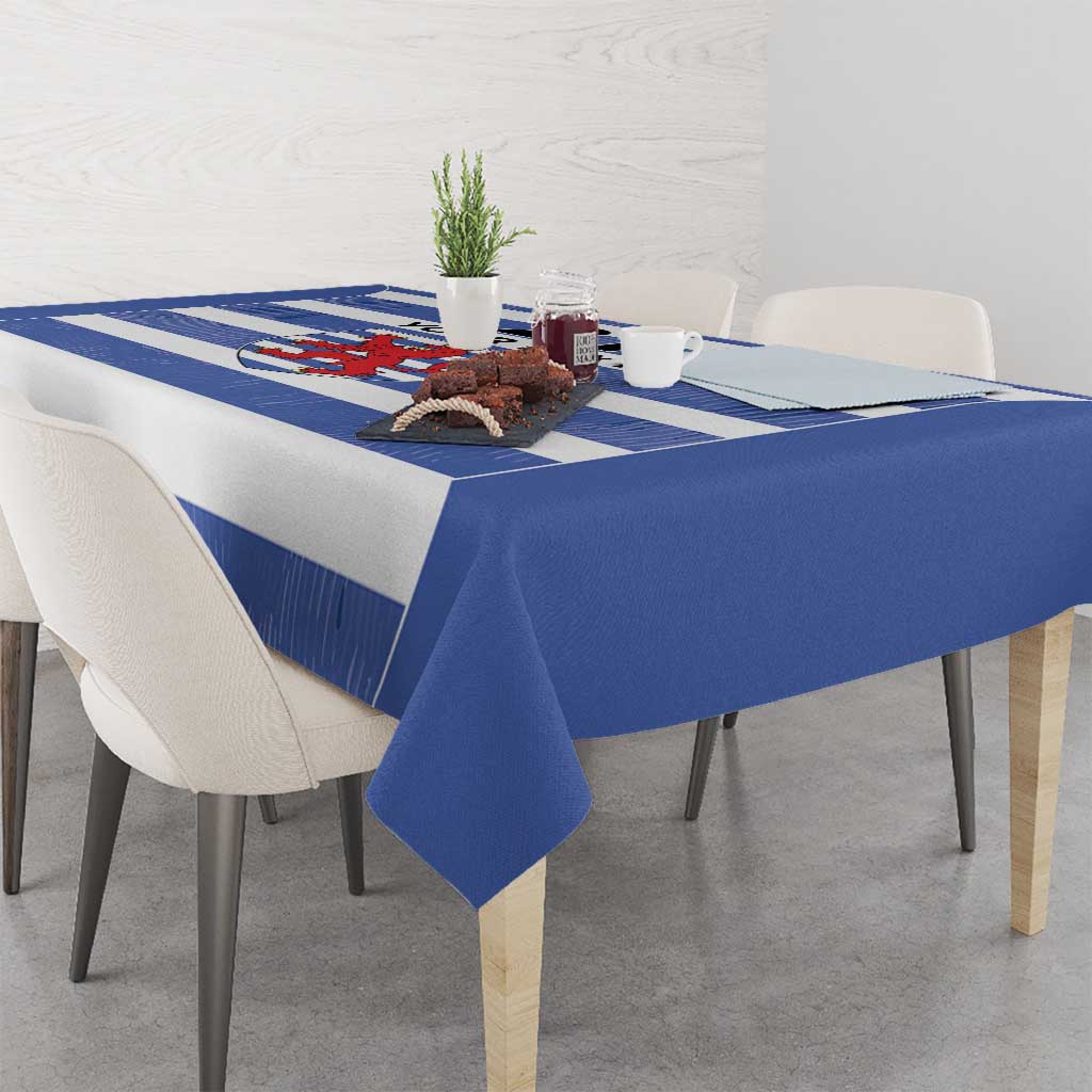 Blue tablecloth with horizontal rugby stripes and crest panel on the table surface