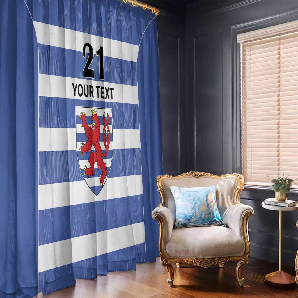 Blue and white striped curtain with red crest motif and custom text, hanging in front of window.