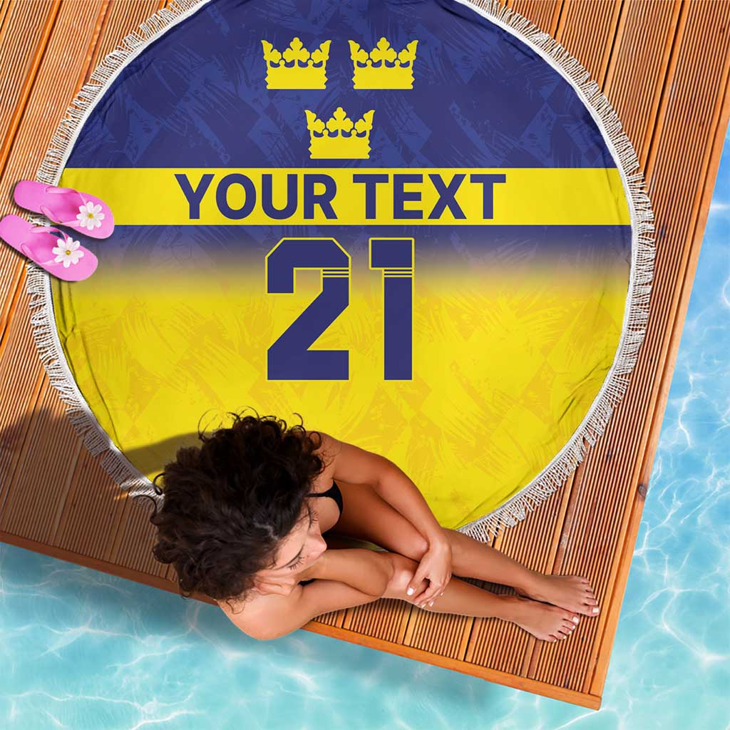 Round beach blanket with blue and yellow flag stripes, crowns, 'YOUR TEXT' and 21, fringe