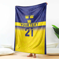 Custom rugby blanket shown draped, blue top with crowns, “YOUR TEXT,” and number 21.