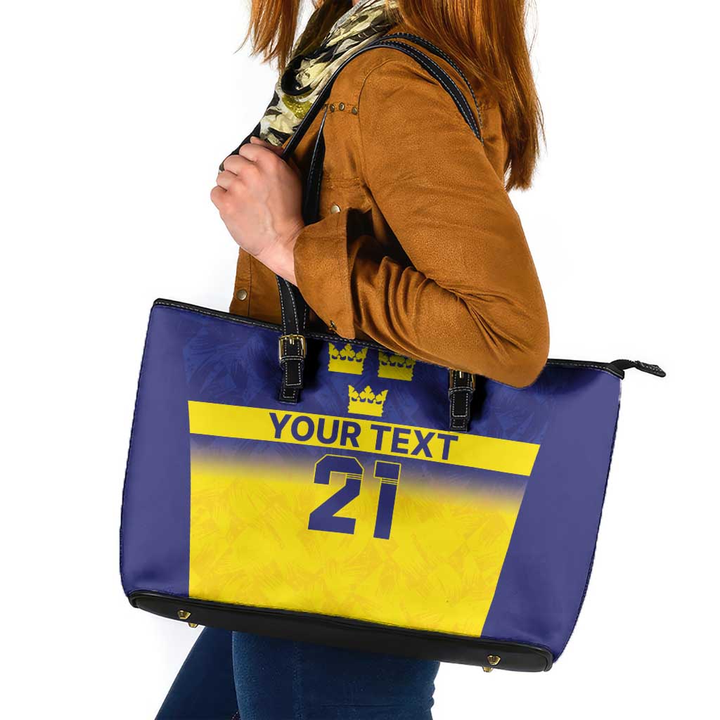 Blue and yellow graphic tote bag with crown icons, zip-top and shoulder handles