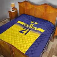 Blue and yellow Sweden-themed quilt on bed, crowns, 'YOUR TEXT' and 21