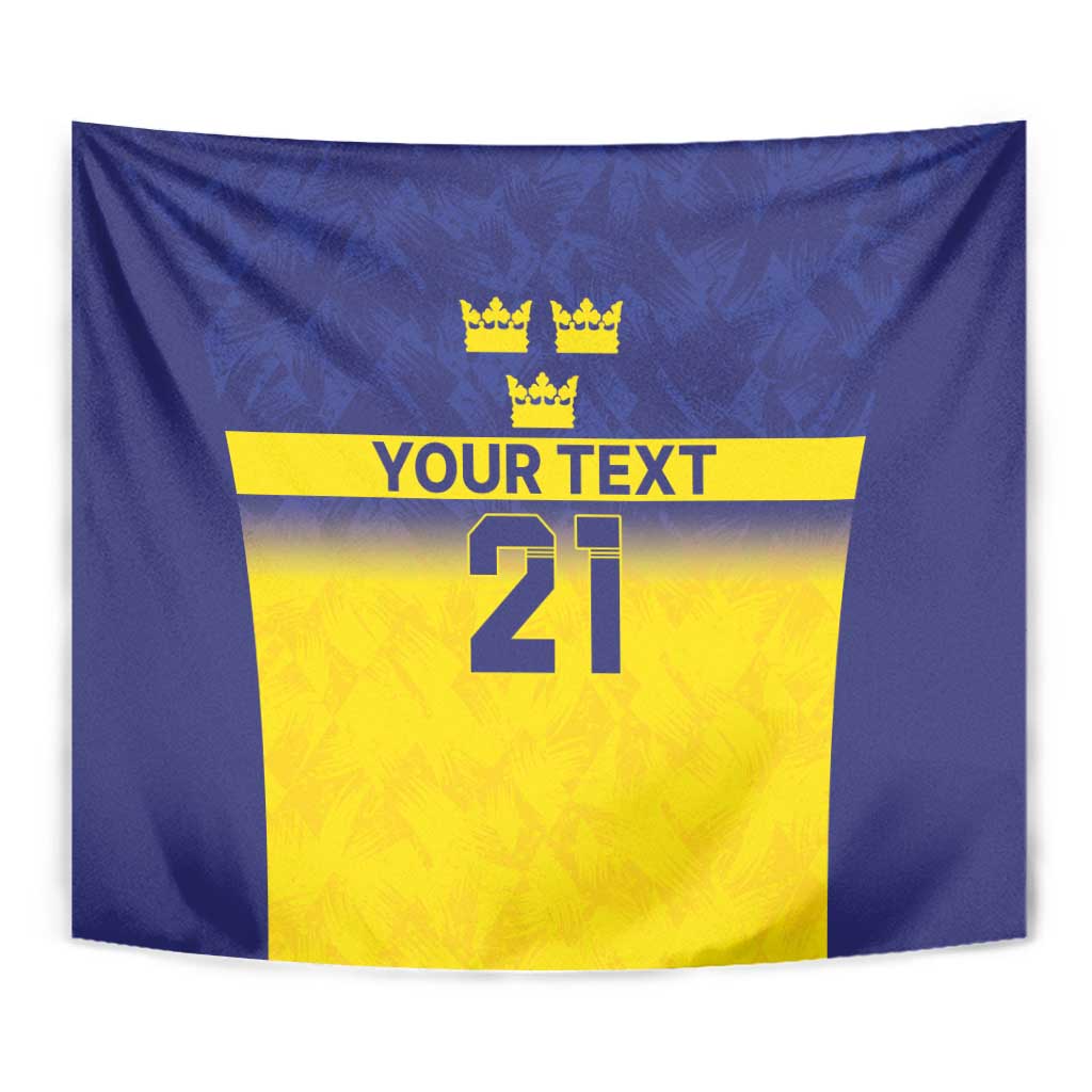 Close-up blue wall tapestry design with three crowns, yellow panel, “YOUR TEXT,” 21