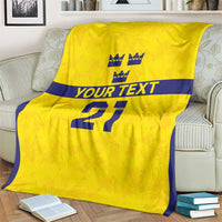 Gold rugby blanket on armchair, navy-edged border, crowns above 'YOUR TEXT' and '21'