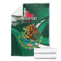 Personalized green blanket folded with eagle artwork, Mexican tricolor stripe and 'YOUR TEXT'.