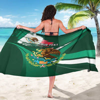 Green Mexican heritage sarong spread out, showing eagle emblem and flag stripe design