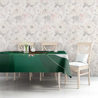 Green tablecloth with eagle-themed border and diagonal stripe design on dining setup.