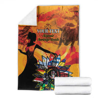 Personalized blanket folded with “Your Text” centerpiece and sunburst emblem, gold and black