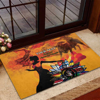 Personalized rubber doormat with gold backdrop, black figures, and colorful flower design near door