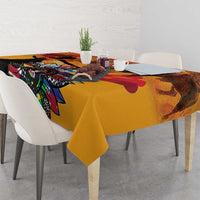 Gold tablecloth draped over dining table with colorful illustrated pattern