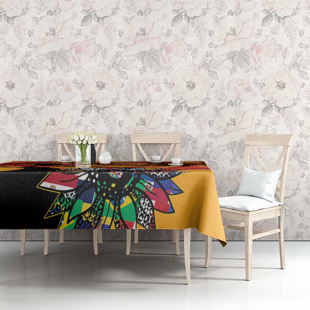 Gold tablecloth with colorful illustrated print on table, floral silhouette motifs