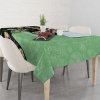 Green tablecloth with black sugar skull and floral skeleton pattern over dining table
