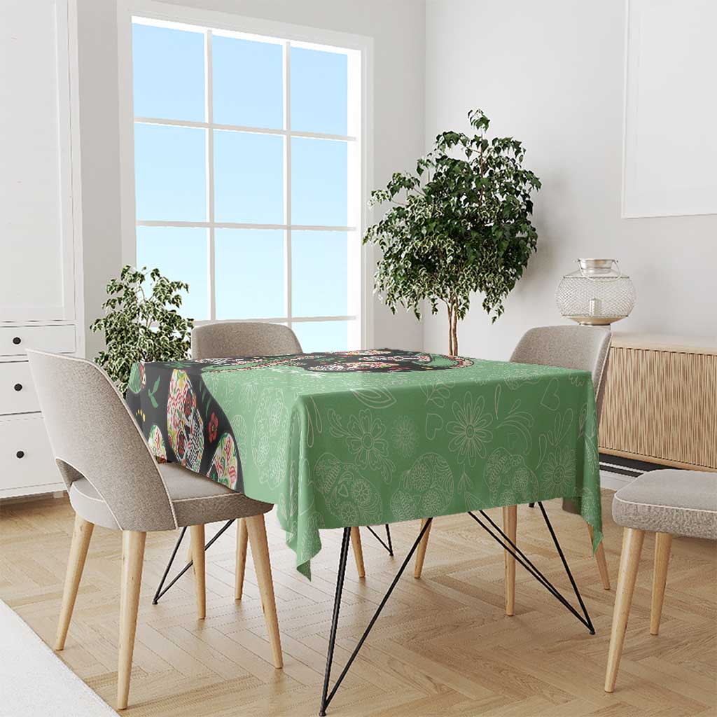 Green tablecloth with black sugar skull design on rectangular dining table
