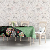 Green tablecloth with black sugar skull artwork along table edge