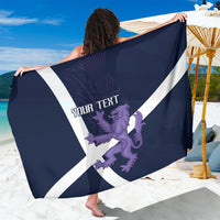 Navy sarong held up showing white diagonal cross and purple lion-and-thistle design