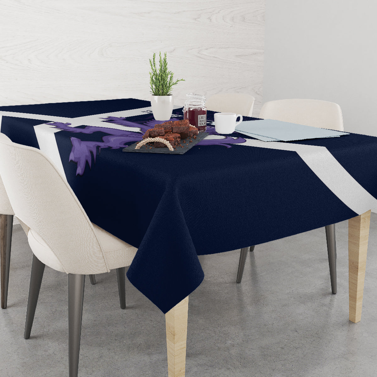 Navy tablecloth with white diagonal stripe and purple lion emblem, tabletop styling