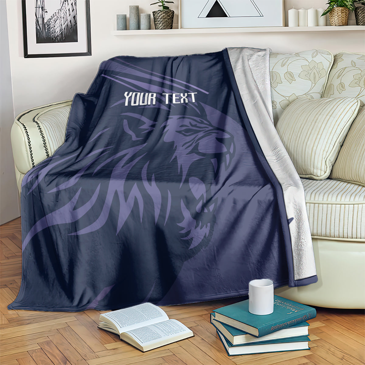 Navy rugby blanket with lion graphic and center "YOUR TEXT" design, draped over furniture