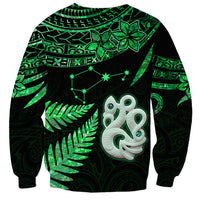 Unisex green and black sweatshirt with Maori manaia face, stars, and fern leaf graphic