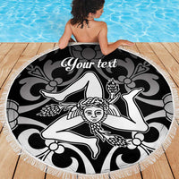 Round black beach blanket with white fringe and central face motif with custom text