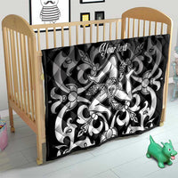 Black quilt blanket in a crib with gray floral swirls and central woman emblem, 'Your text'.