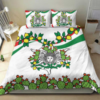 White duvet and two pillows with green cactus, yellow lemons, and triskelion-style face design
