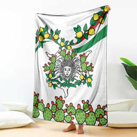 White blanket spread on floor showing cactus, lemons, and central woman face design.